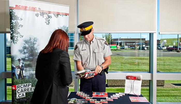 RCMP officer talking to a civilian at a booth