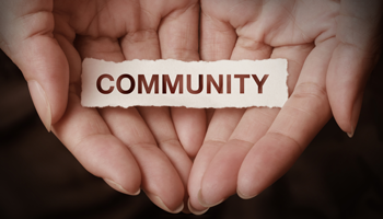 photo of open hands holding a community sign