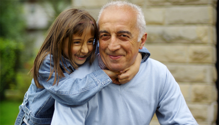 A photograph of a grandchild hugging their grandfather