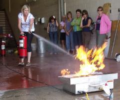 Image of a woman taking fire Extinguisher Training