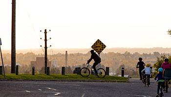 Family cycling in Red Deer at sunset