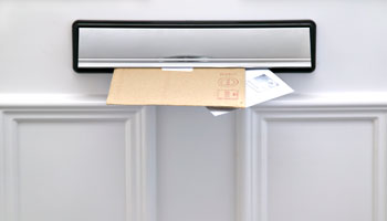 image of mail coming through mail slot in the door