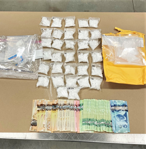 Table with mulitple packets of Methamphetamine, cash, and other items seized on March 25 and 26
