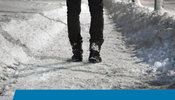 Man walking down a snowy shoveled sidewalk