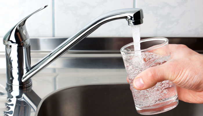 running tap filling a glass of water