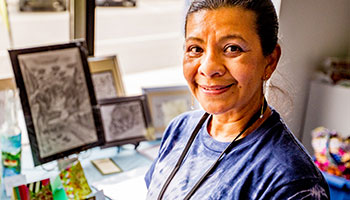 photo of a woman with her artwork in the background