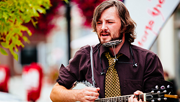 Downtown musician playing banjo and harmonica