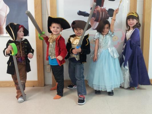 Photograph of five young children, boys and girls dressed in costumes as pirates and princesses.
