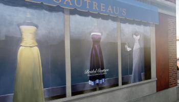 Painted mural of dresses hanging in a store front window.