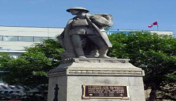 Color photograph of the cenotaph of Major Frank Norbury taken at sunset. He is dressed in soldier apparel from the First World War.