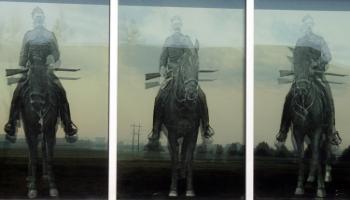 Three glass windows with an RCMP officer on horseback etched in the glass on each one.