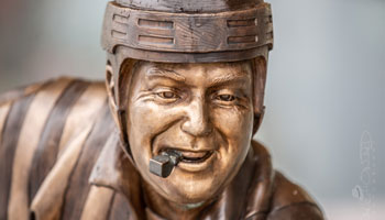 Hockey referee's face with a helmet on his head and a whistle in his mouth