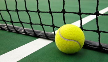 photo of tennis ball and net on a tennis court