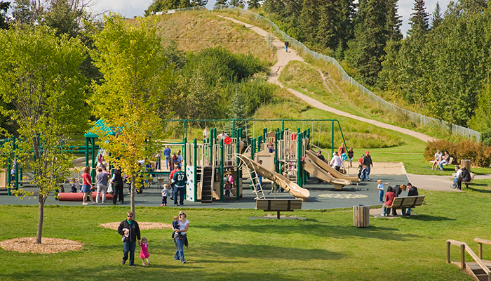 Playground at Rotary Park with lots of families enjoying the amenity