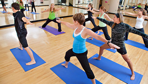 People participating in a yoga class inside the Motion Studio at the Collicutt Centre